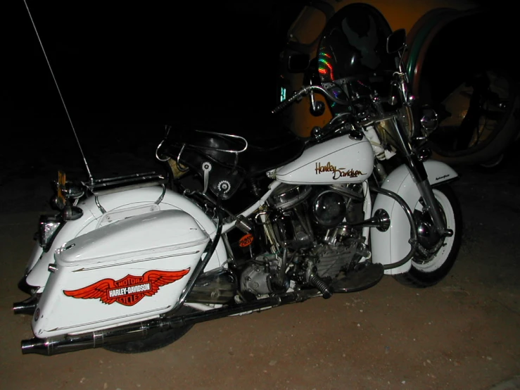 a white motorcycle parked in a parking lot at night