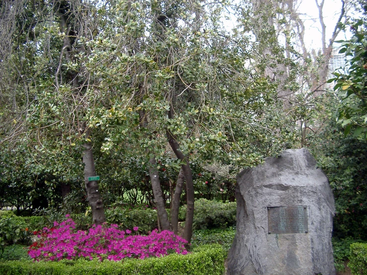 a sculpture in the middle of some shrubs and trees