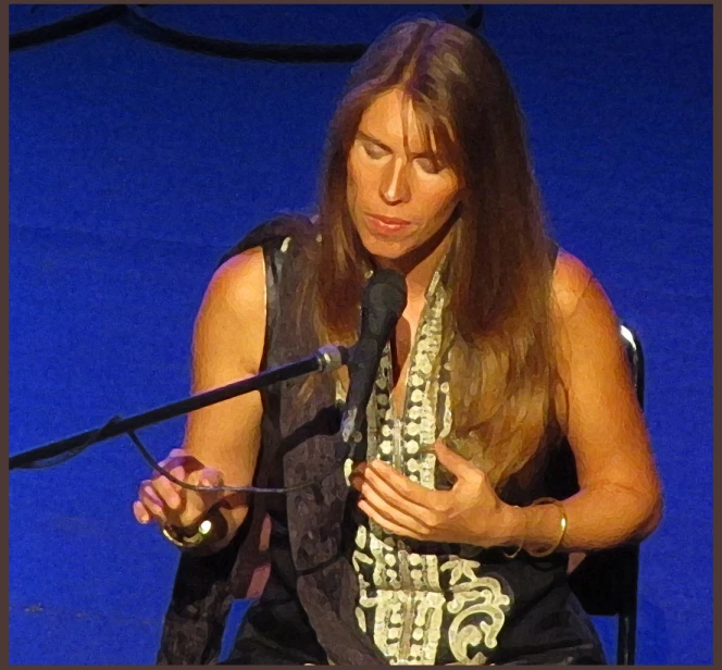 a woman speaking into a microphone in front of a blue background