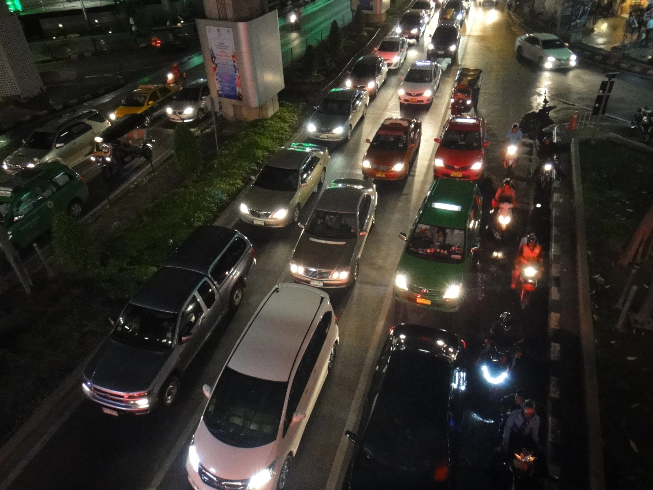 a group of cars driving down a street at night