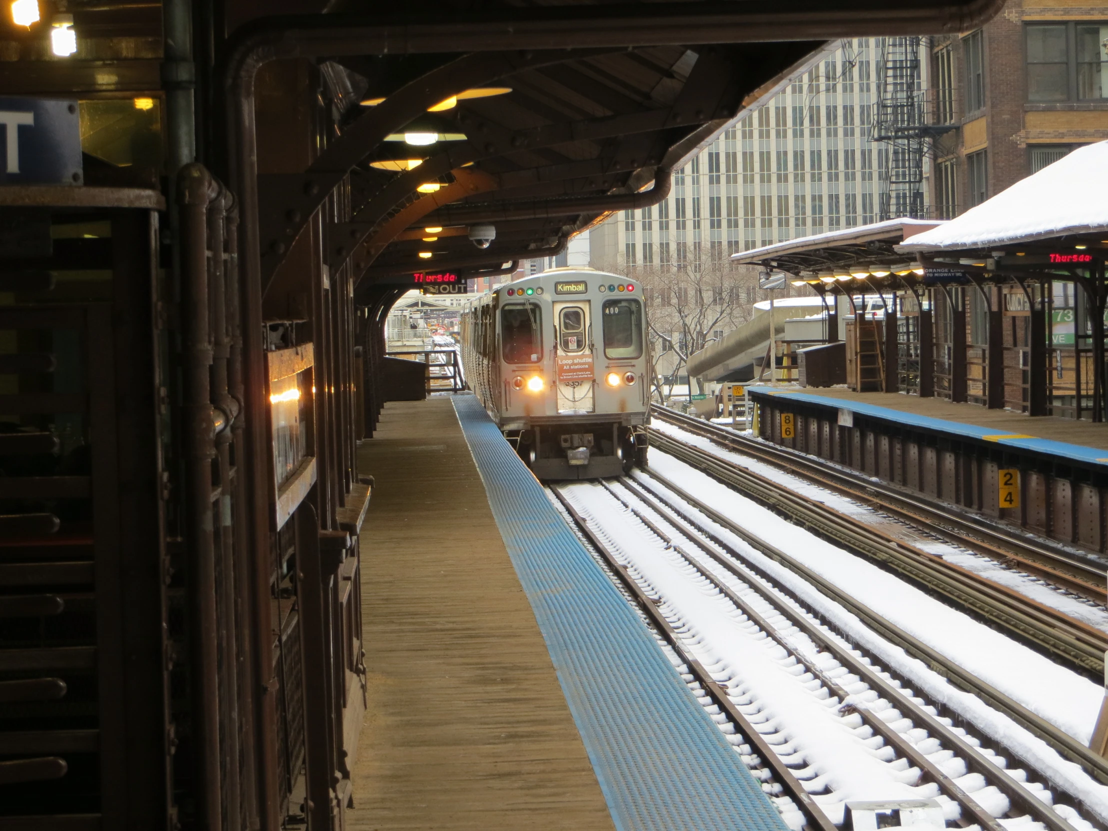 a long train at a train station in the snow