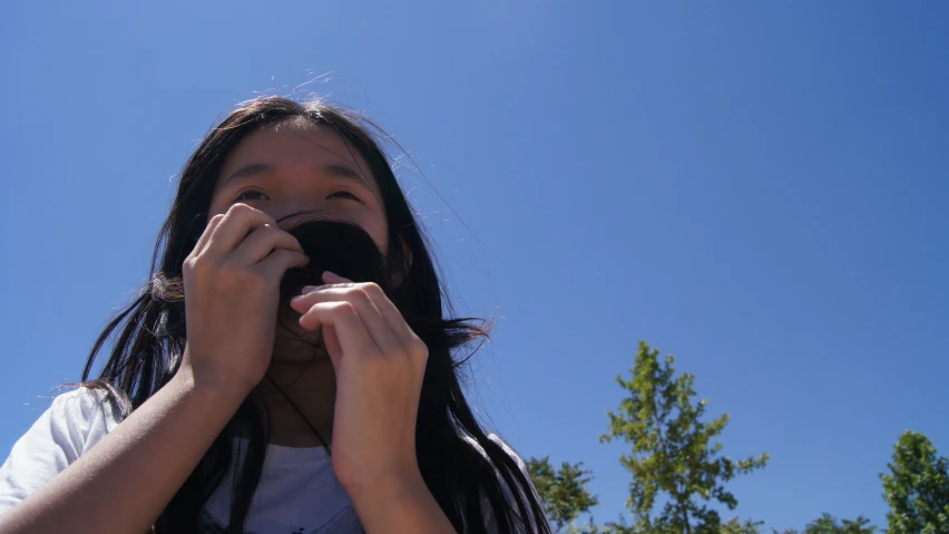 a woman looking up while holding her hands to her face