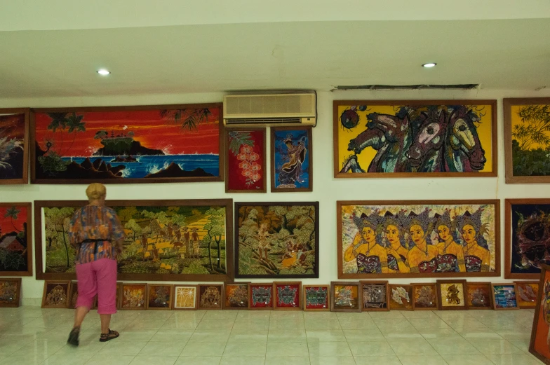 a wall is covered in many paintings and artwork