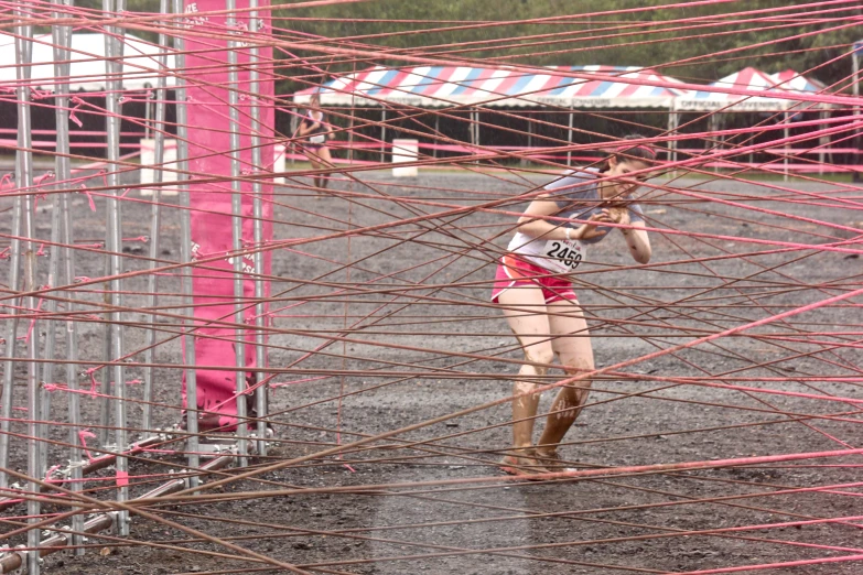 a girl with a tennis racket in between pink bars