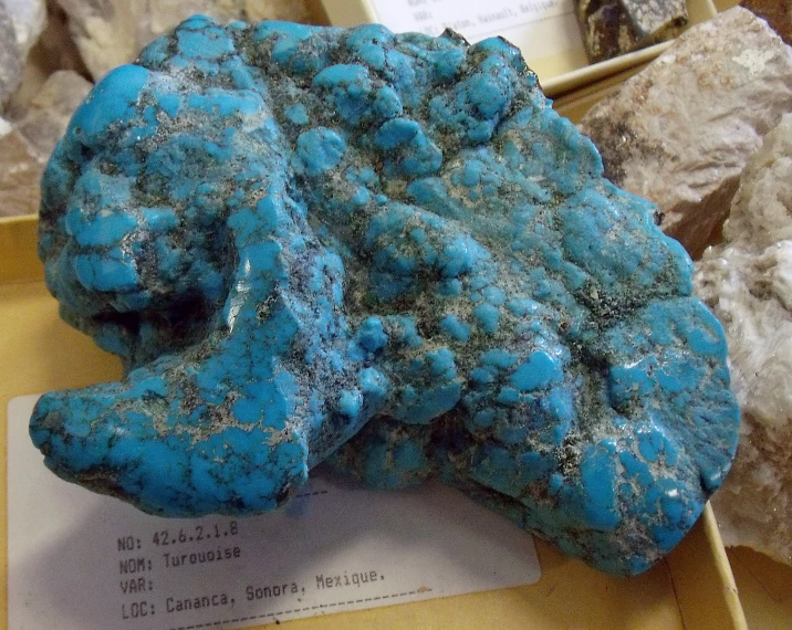 some turquoise colored rocks with dirt and rocks surrounding them