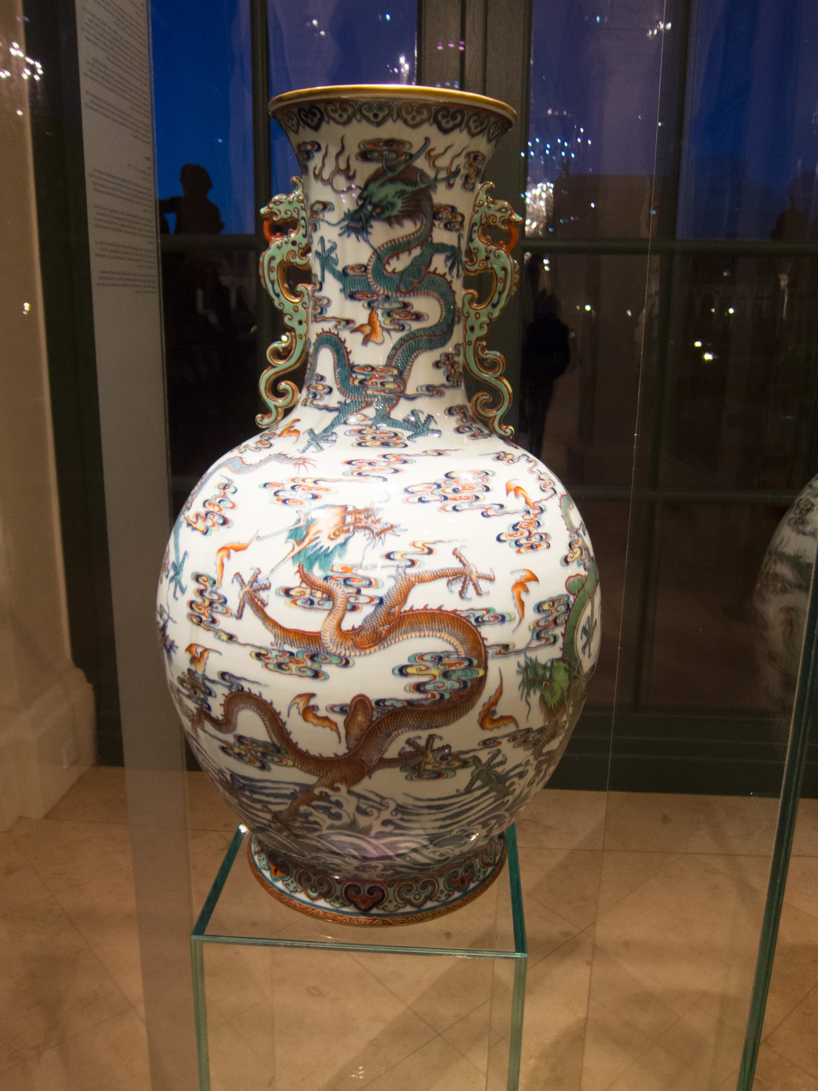 a large vase with different designs sitting on a stand