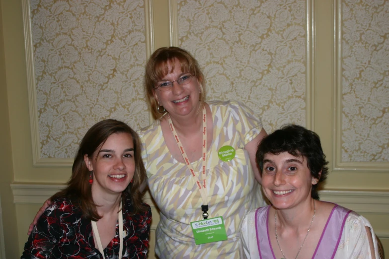 three women are posing for a po, both smiling