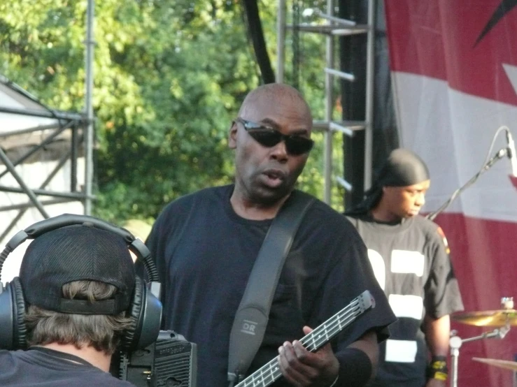 a man playing the guitar while listening to someone else