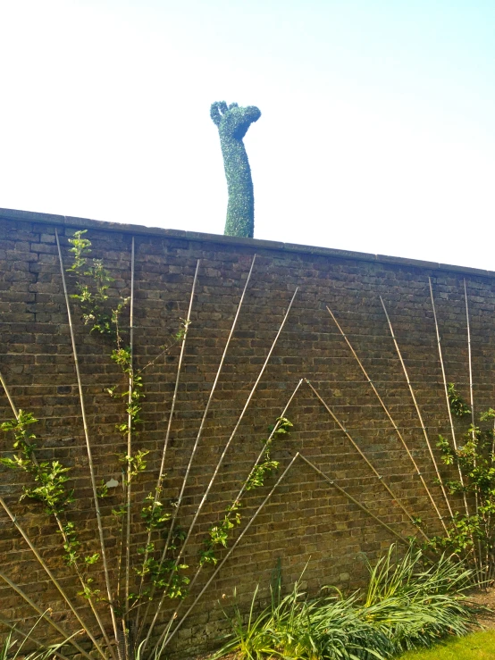 a tall sculpture is placed on the side of a building