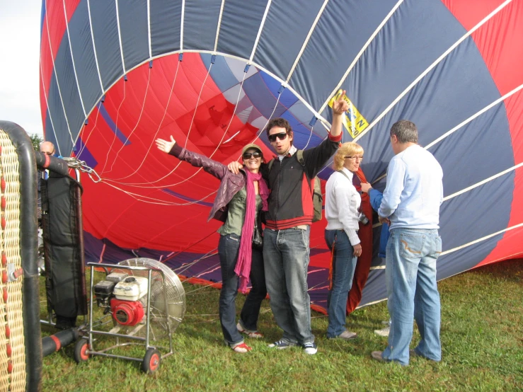group of people standing around a giant colorful air balloon