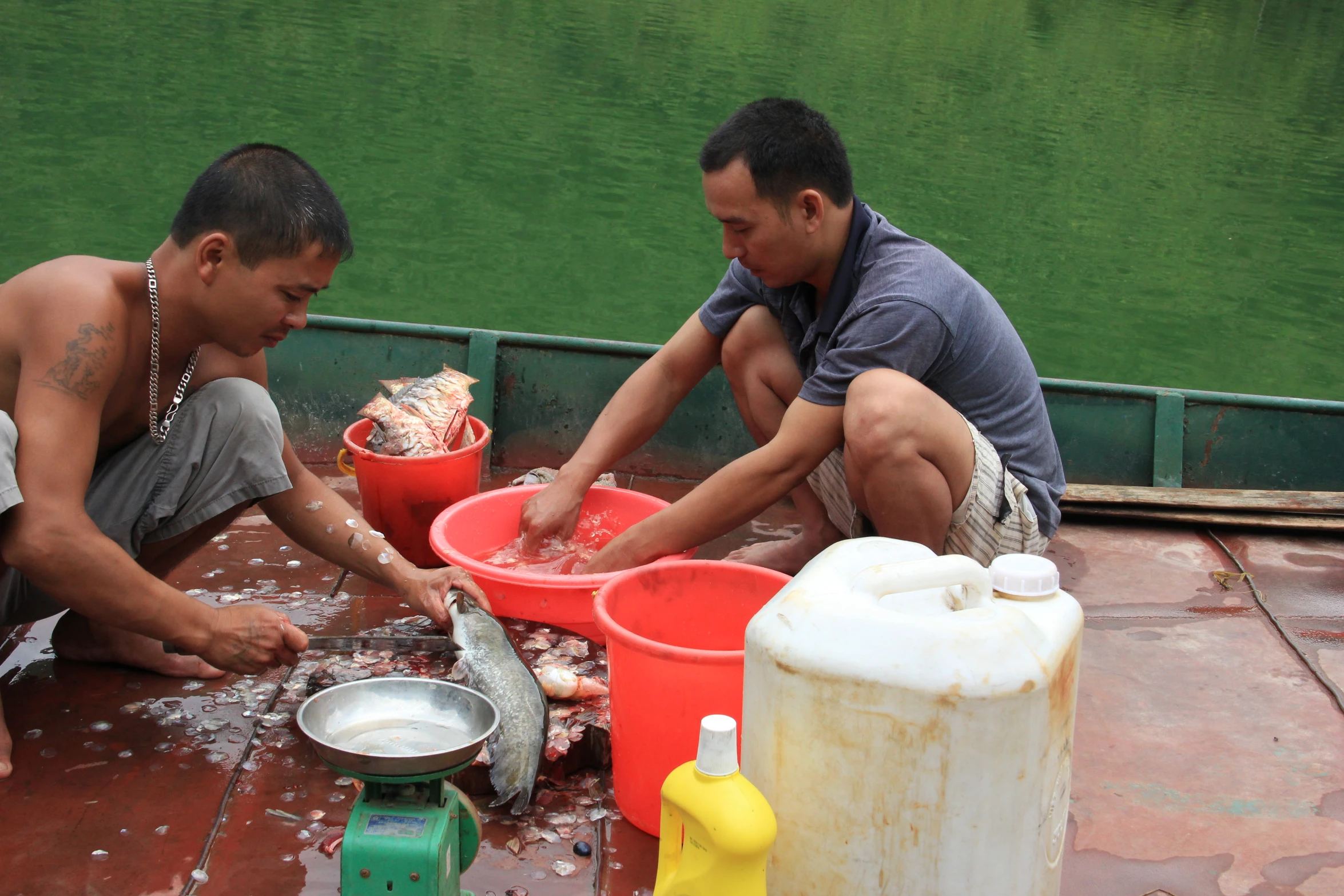 two men working on a table while cooking fish