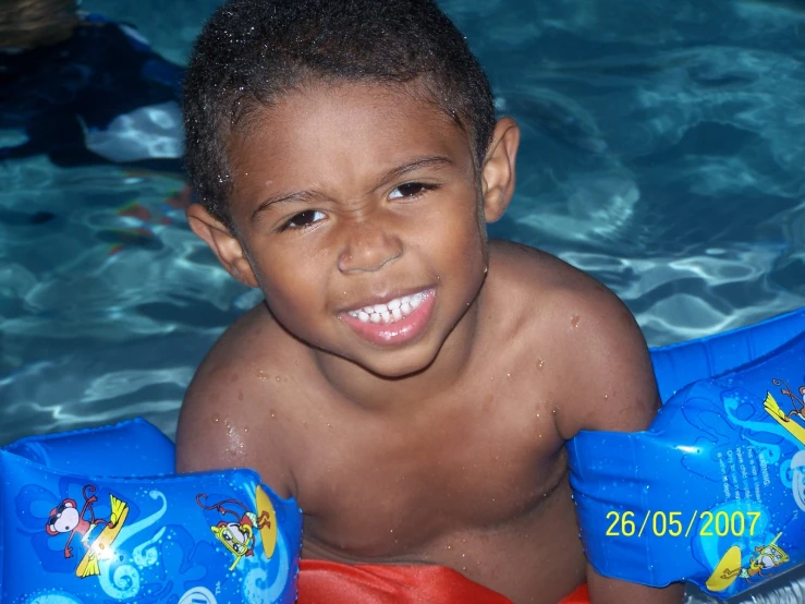 boy with two water shoes in a pool