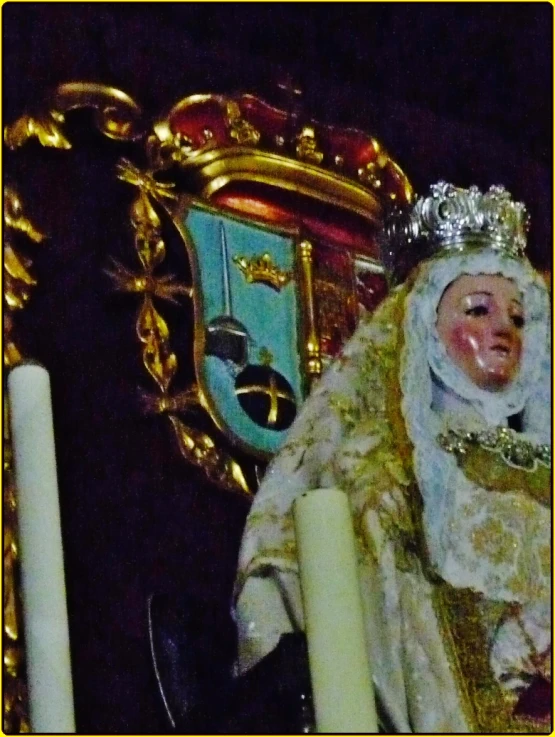 statue next to clock that says a crown and candles