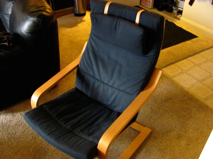 a blue recliner sitting next to a black couch