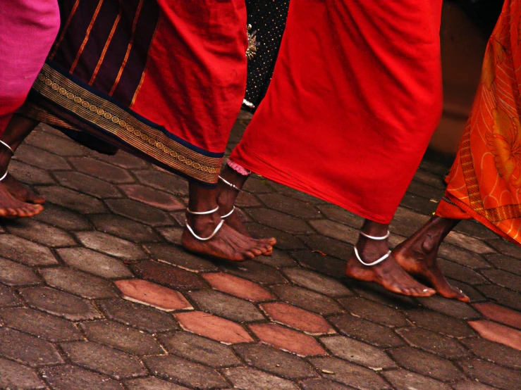 three people in red pants standing around on the street