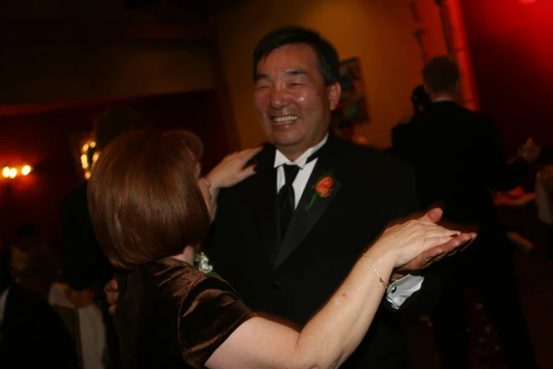 a couple dancing at a social event in a dark room