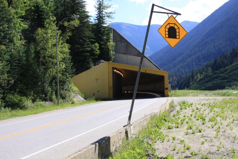 a yellow road sign sitting on the side of a road