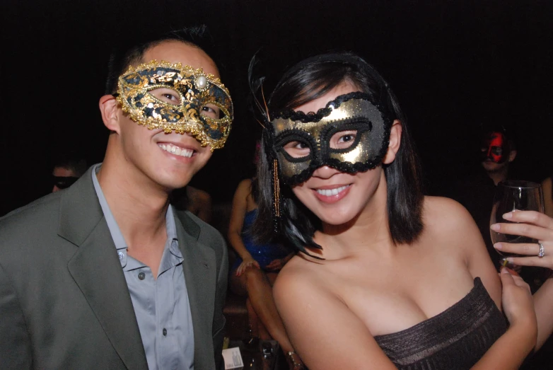 a man and woman wearing masks at a masquerade party