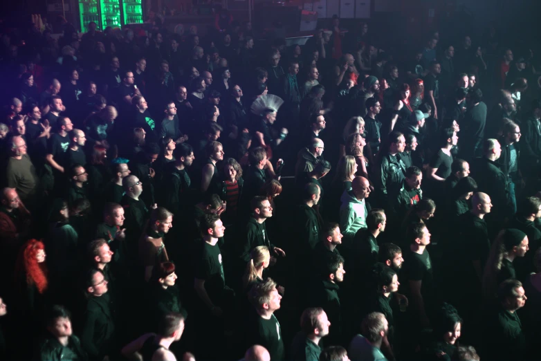 a crowd of people who are standing in the dark