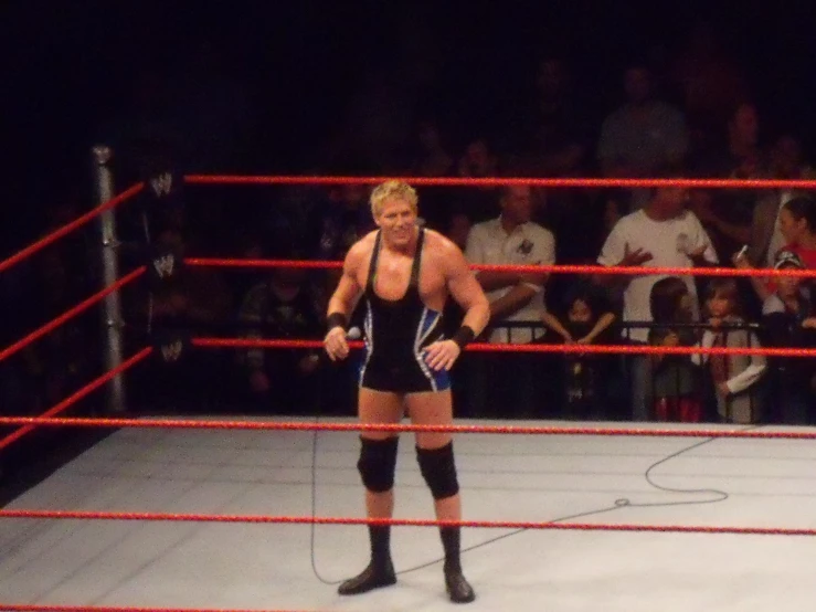 a wrestling man in the ring with his hand on his hip