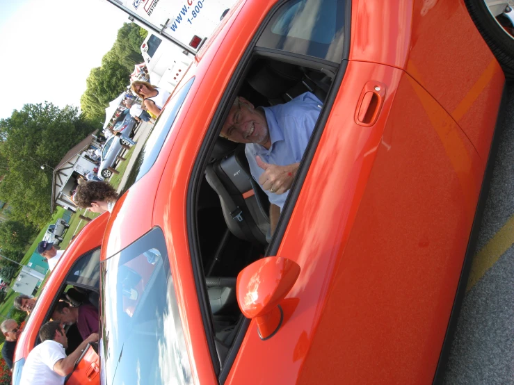 an older man in his car giving the thumbs up