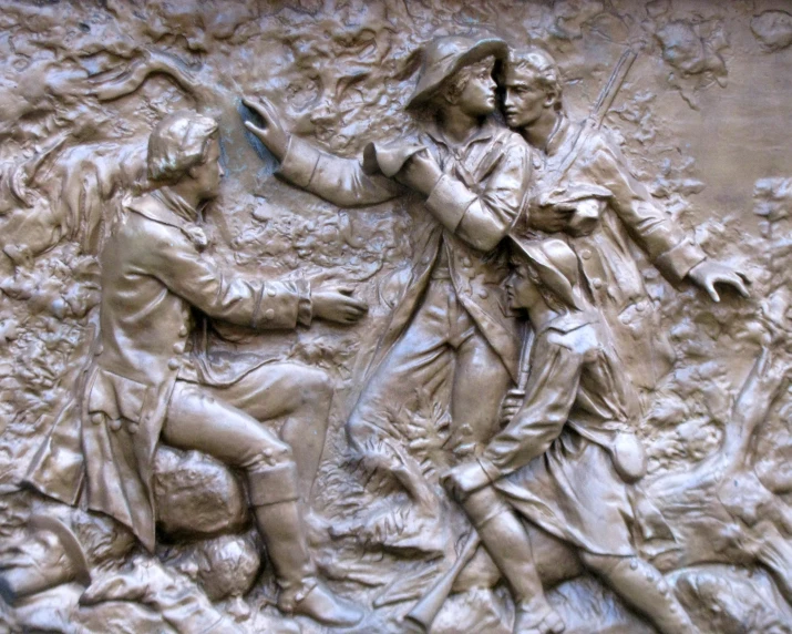 sculpture of soldiers on wall holding hands