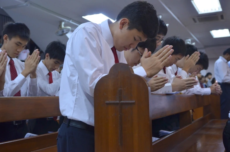 some boys wearing red ties standing in a church