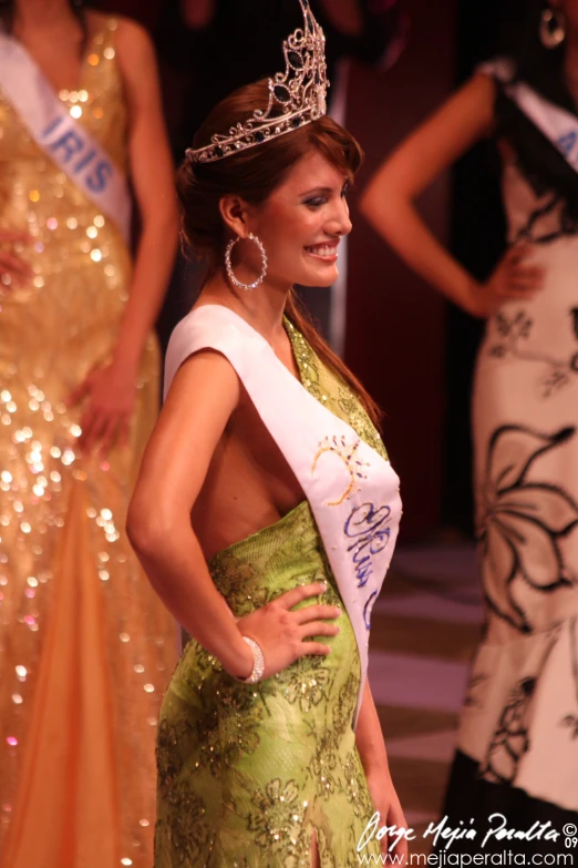 the young woman in the gown is holding a tiara