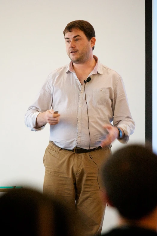 a man speaking at an event in front of a group