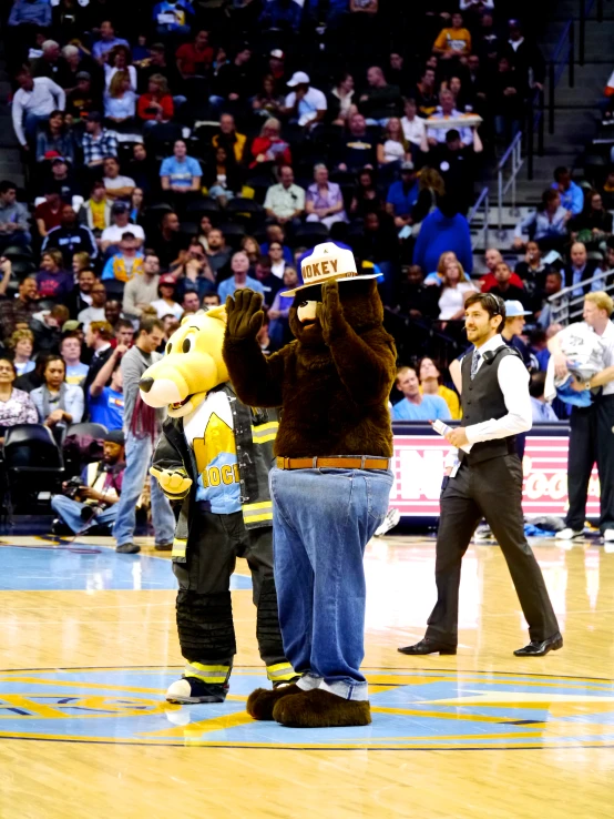 some fans watching and having fun with the mascot