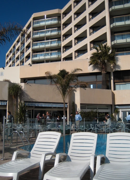 a el has a swimming pool with two rows of lawn chairs