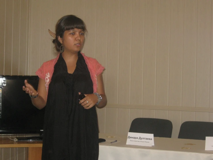 a woman giving a speech with a speaker in the background