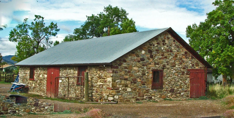 an old building made of rocks and stone, with a small boat on the front