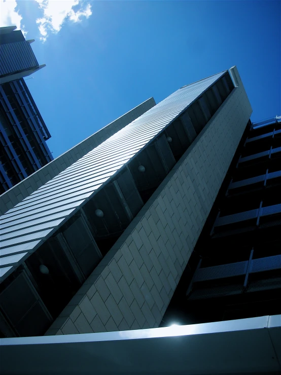 looking up at tall buildings with the sky in the background