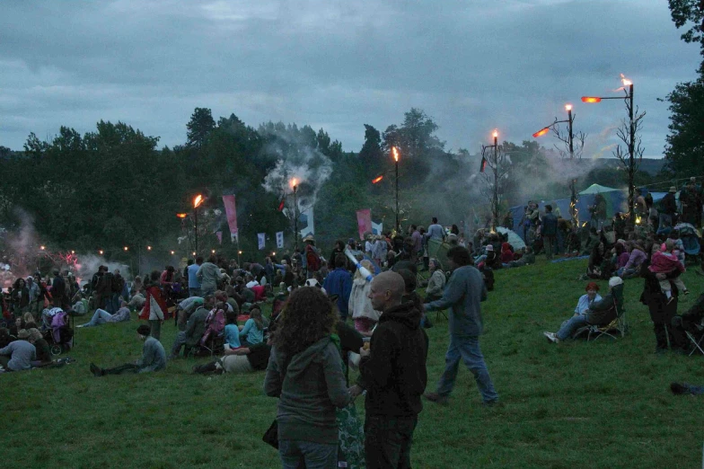 a group of people sitting on top of a lush green park