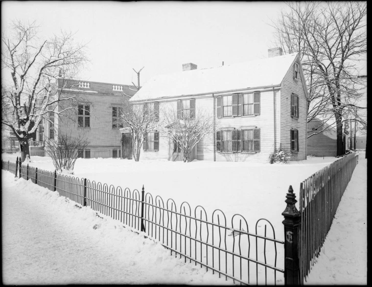 a snow covered yard with a fence and house