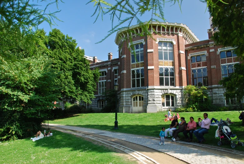 a group of people sitting in front of a brick building