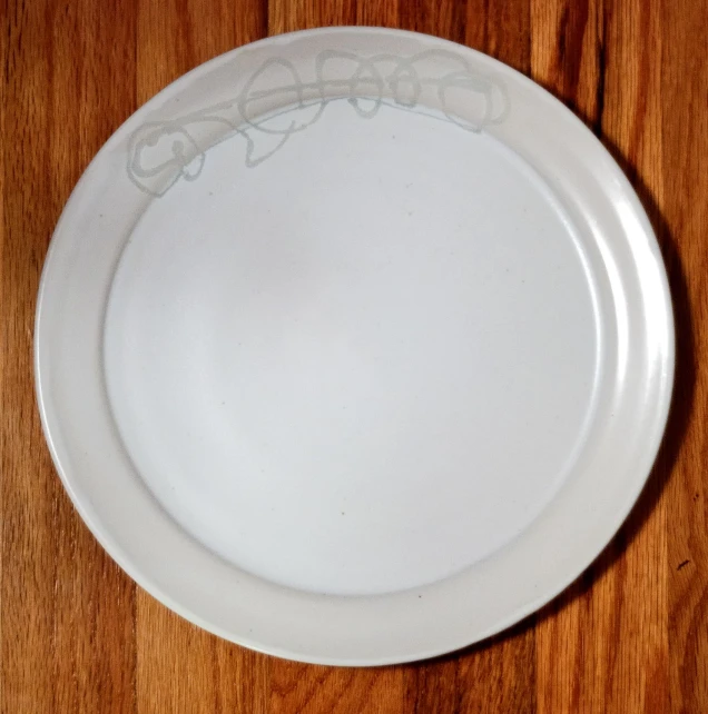 a white plate sitting on a wooden table