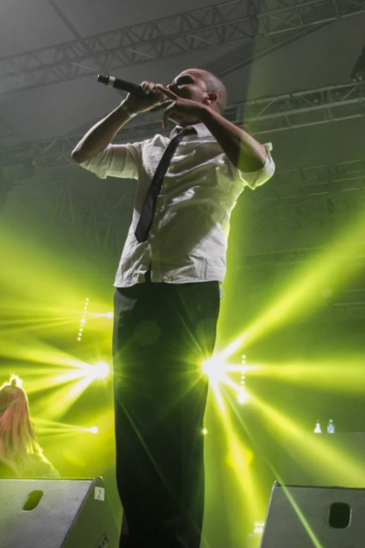 a man standing in front of a stage while holding a microphone