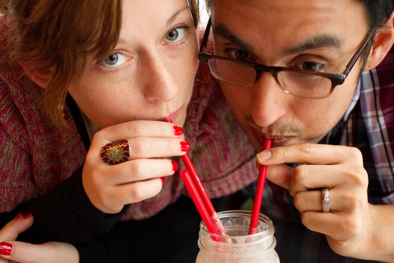 two people in red dress drinking milk and looking at the camera