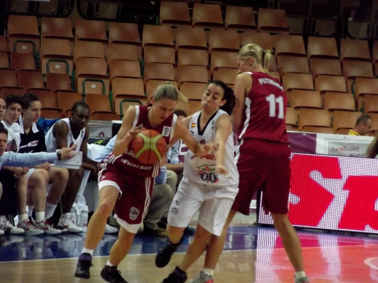 a group of women standing on top of a basketball court