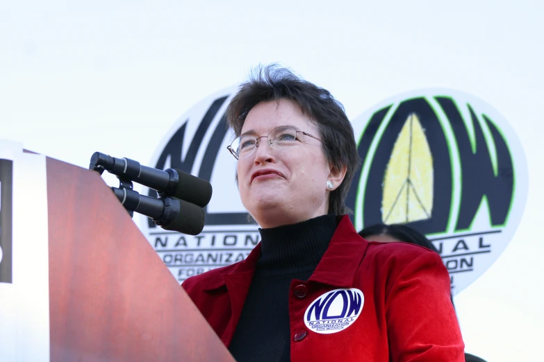 a woman speaking on a podium next to two oval shaped sign