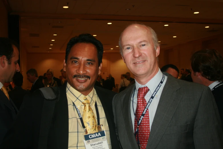 two men standing next to each other in a room