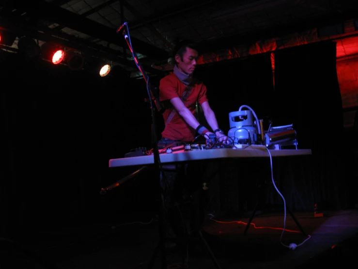 a male dj performing with a white mixer and mixing equipment