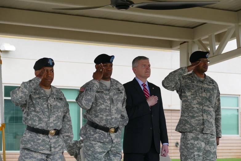 men in military uniforms are saluting each other