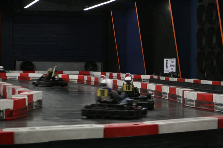 people driving go karting in the track with white and red lines