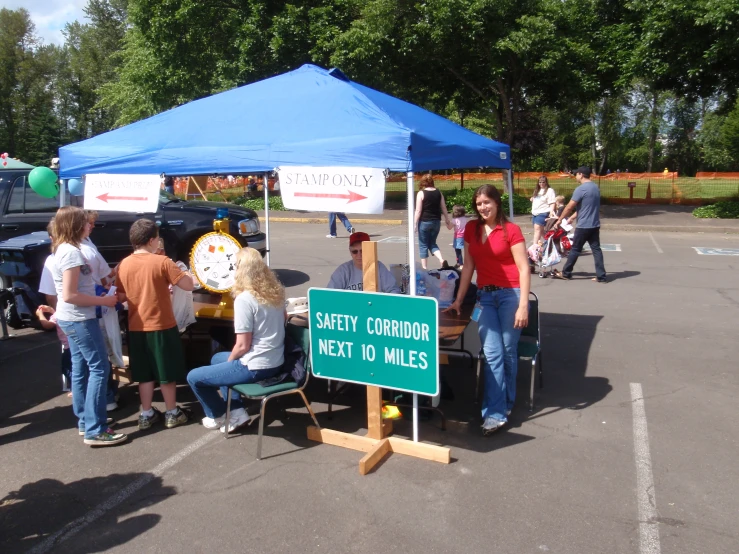 a group of people gathered around a sign under a tent