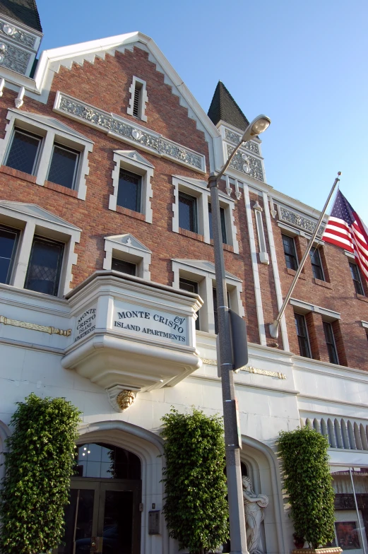 a flag flies above the entrance of an old brick building