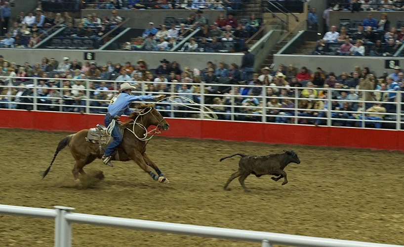 a man riding on the back of a bull as it falls