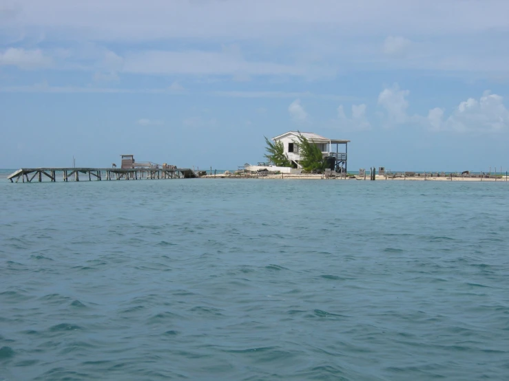 an island in the ocean with house on it